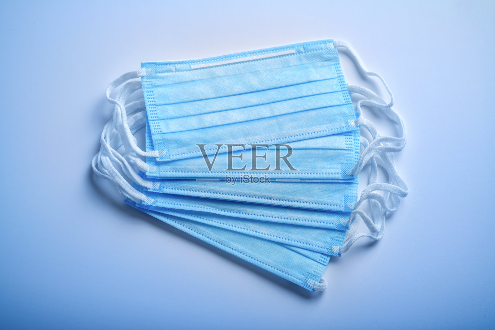医用防护口罩蓝色背景- Covid - 19防护照片摄影图片