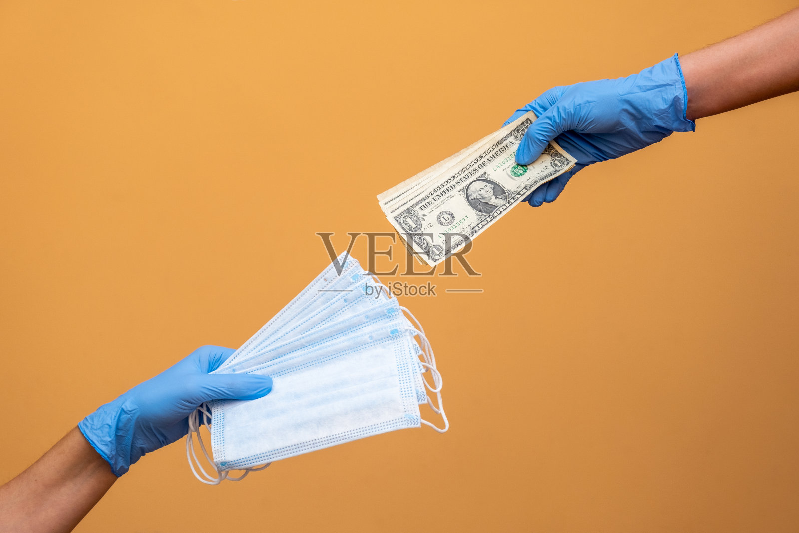 一双手做着买卖口罩和美元的生意照片摄影图片