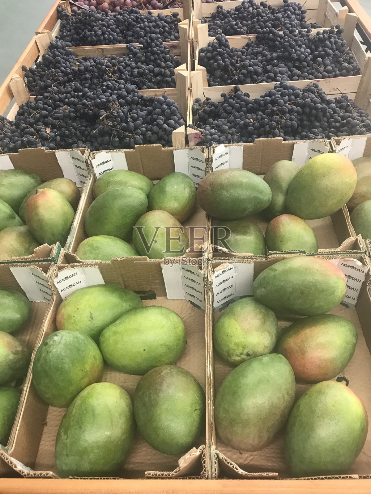 装着蔬菜和水果的盒子放在超市的货架上，出售照片摄影图片