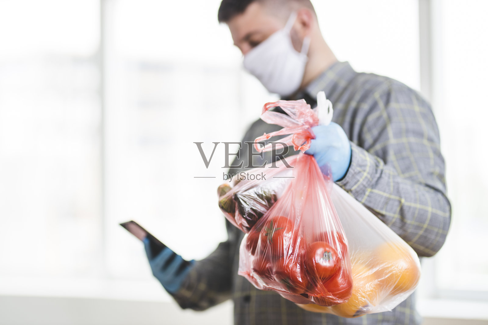 送货员拿着装着水果和蔬菜的塑料袋照片摄影图片