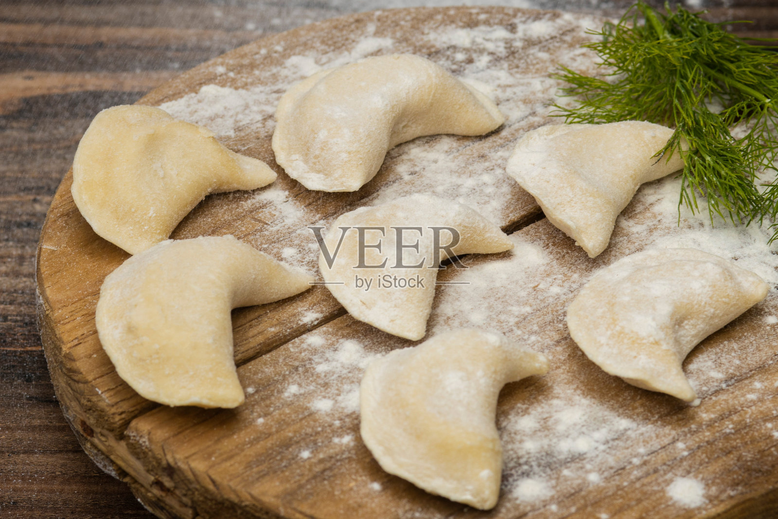 木背景上的木盘子上的速冻饺子照片摄影图片