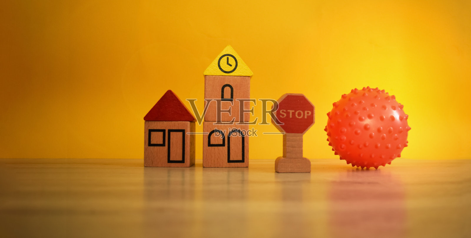 玩具木屋和一个红球。一张在甲型h1n1流感大流行期间用玩具来引起人们对自我隔离话题的关注的图片。照片摄影图片