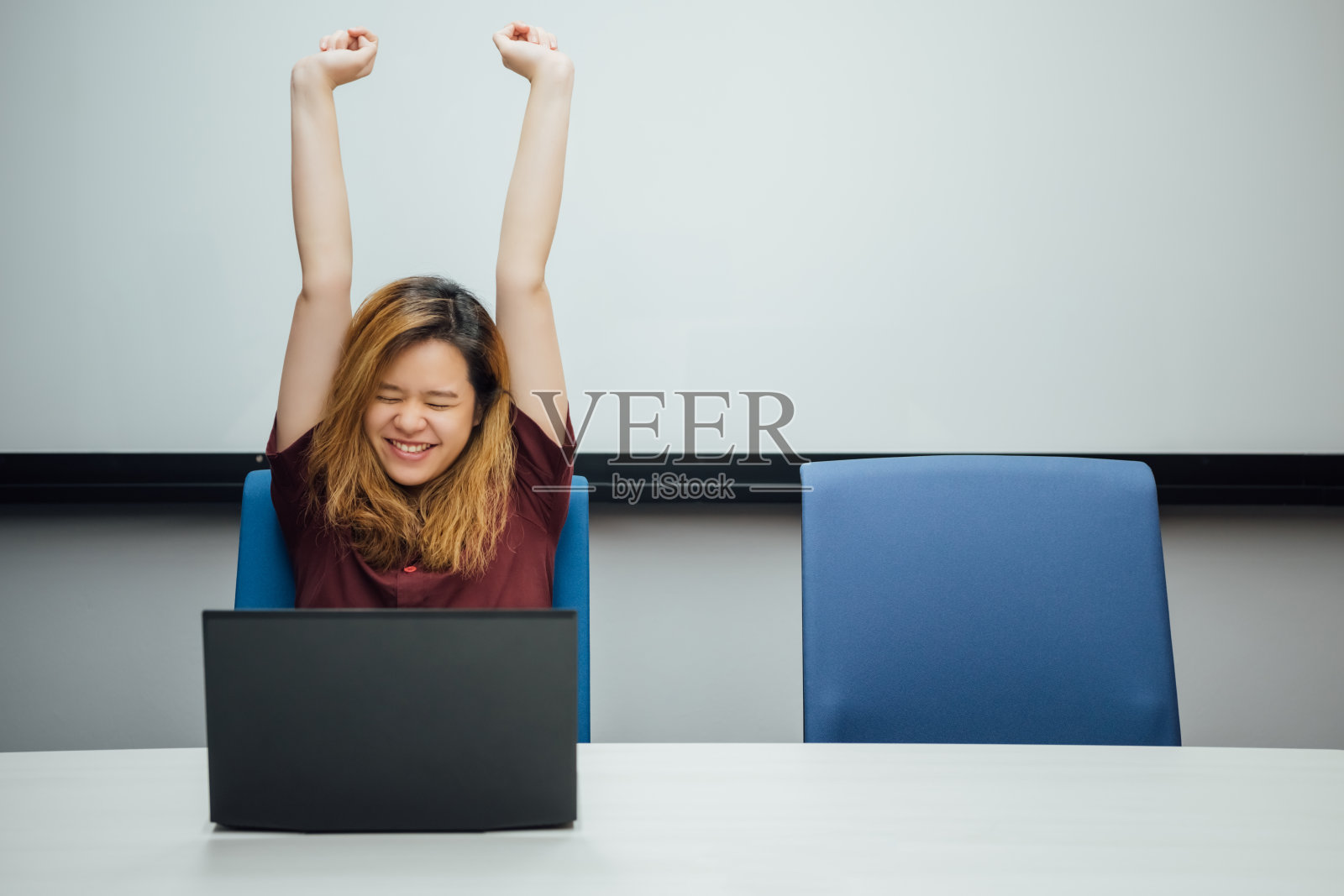 在办公室用笔记本电脑工作的女人很开心照片摄影图片