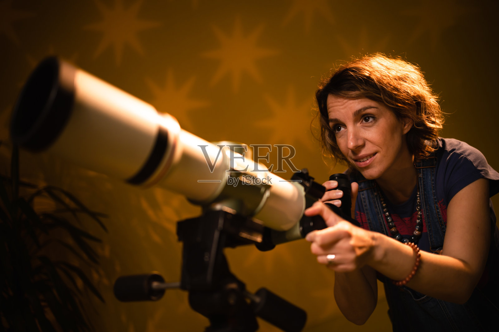 女人通过望远镜看星星——占星术的概念，占星术预测未来。照片摄影图片