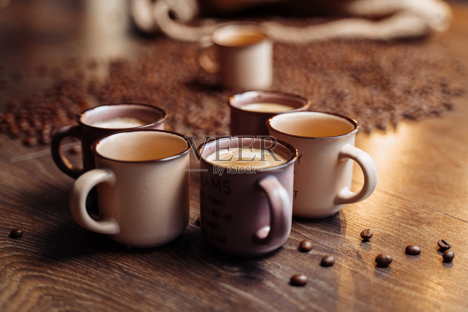 一个咖啡袋和咖啡豆躺在木地板上。有一杯咖啡色的咖啡。照片摄影图片