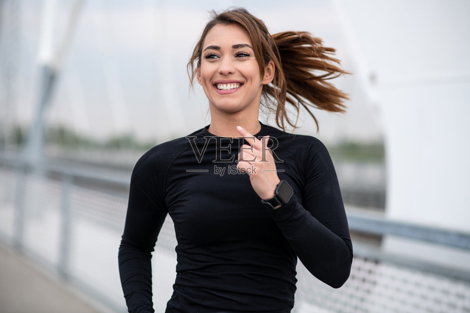 女运动员在桥上跑步照片摄影图片