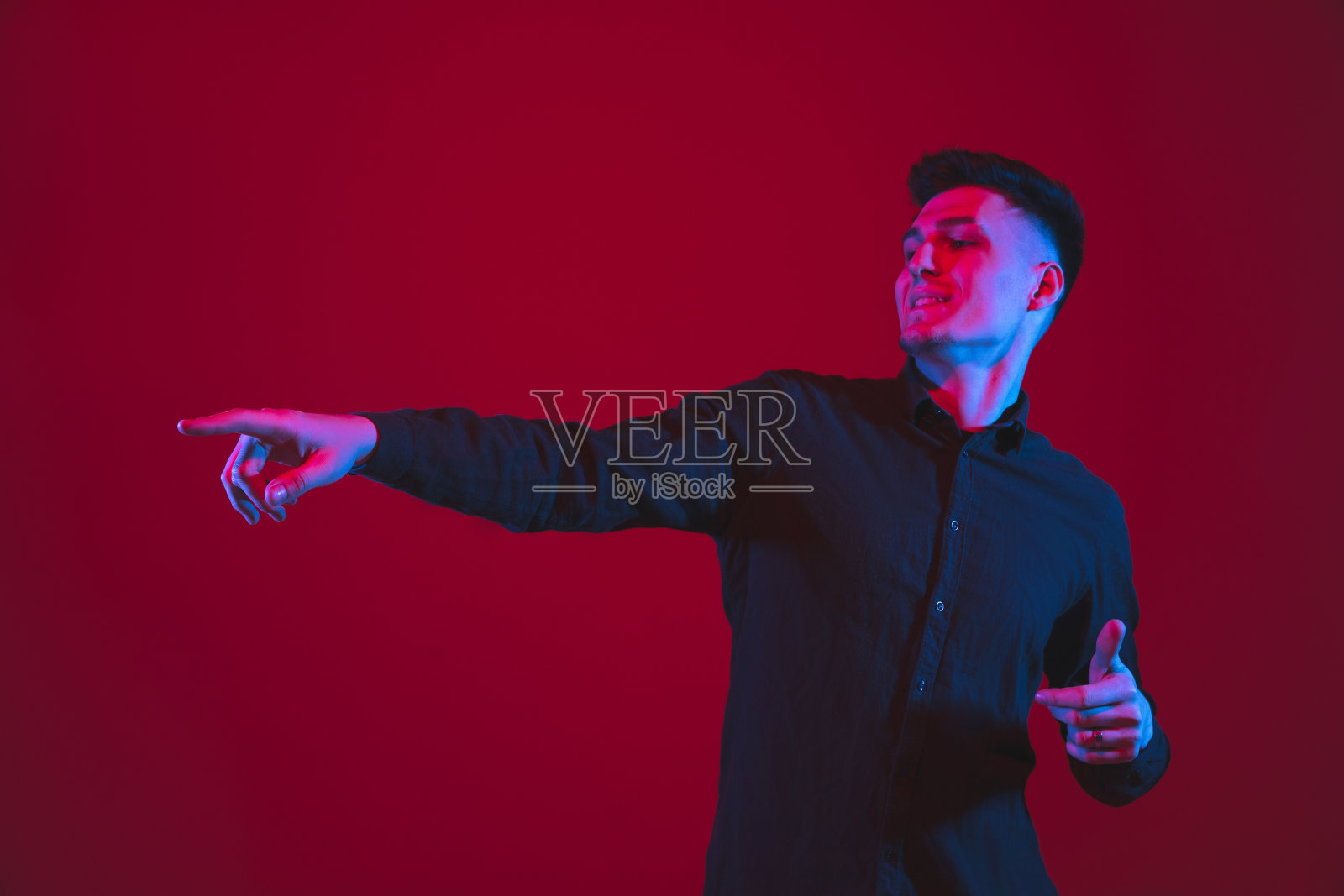 一个白人男子的肖像孤立在红色的工作室背景紫色的蓝色霓虹灯，情感和美丽照片摄影图片