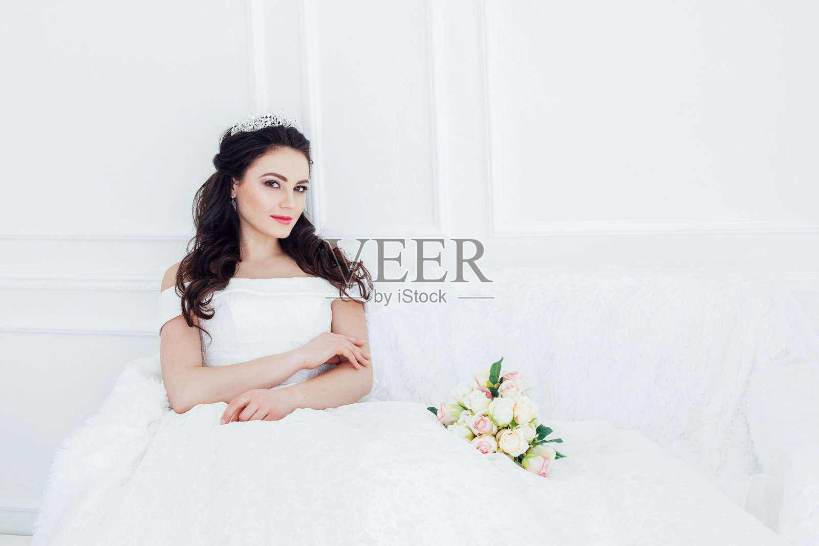 新娘穿着婚纱坐在沙发上捧花照片摄影图片