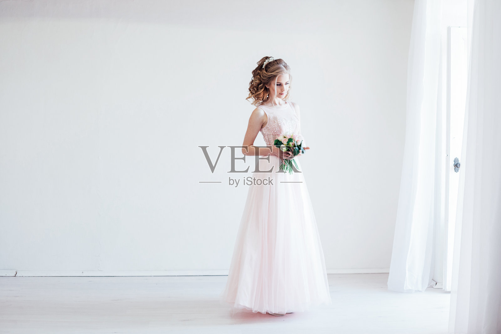 温柔的新娘在婚礼前的白色房间里照片摄影图片