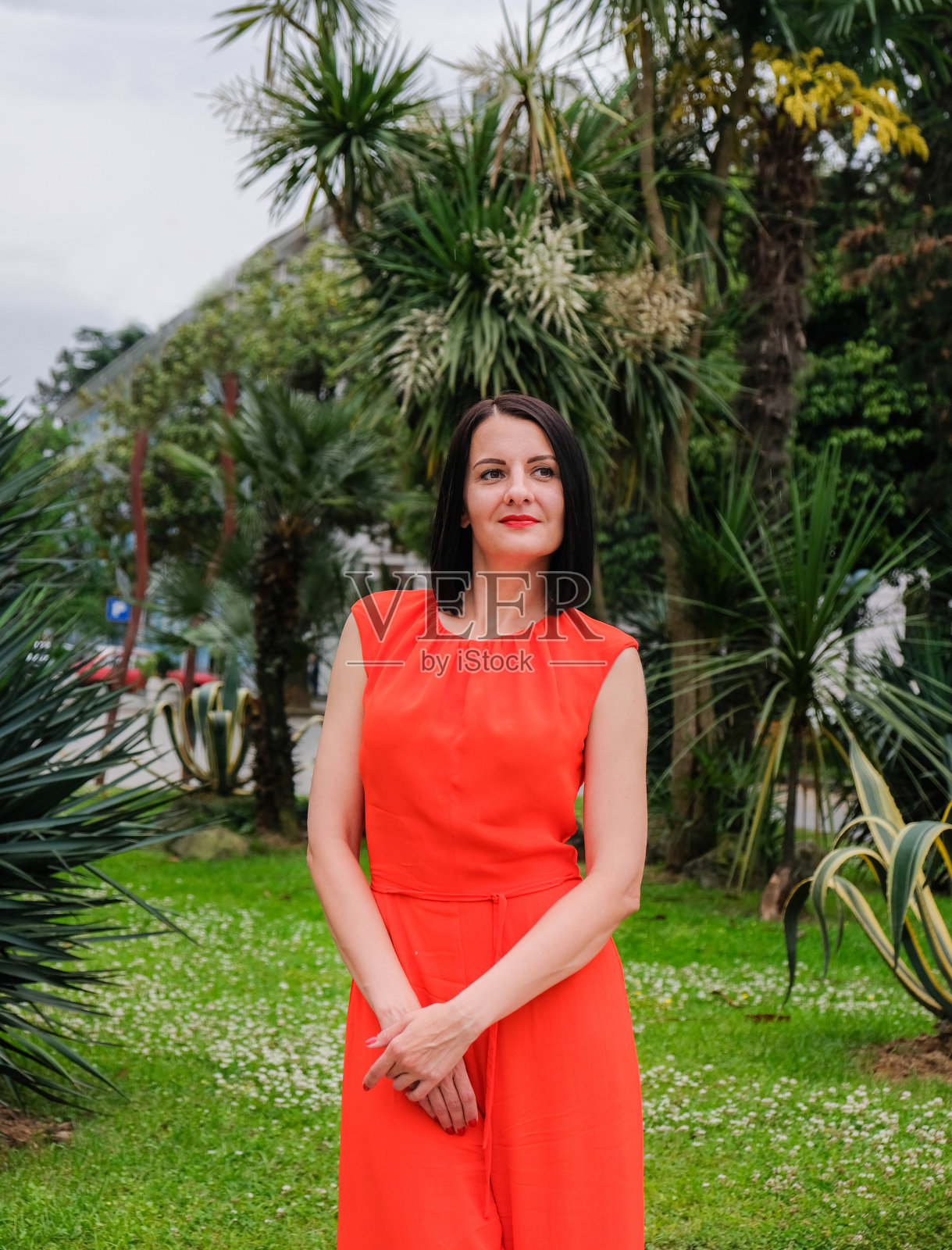 穿着红色套装的黑发模特。照片摄影图片