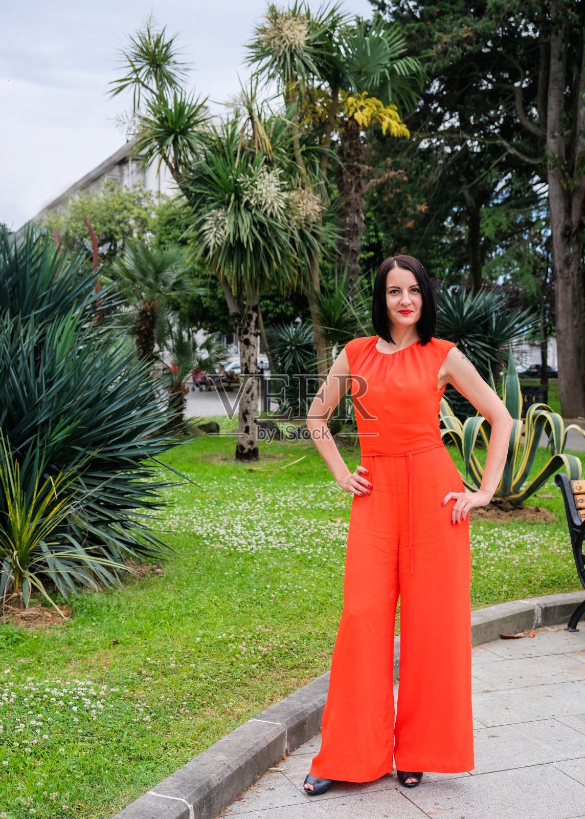 穿着红色套装的黑发模特。照片摄影图片