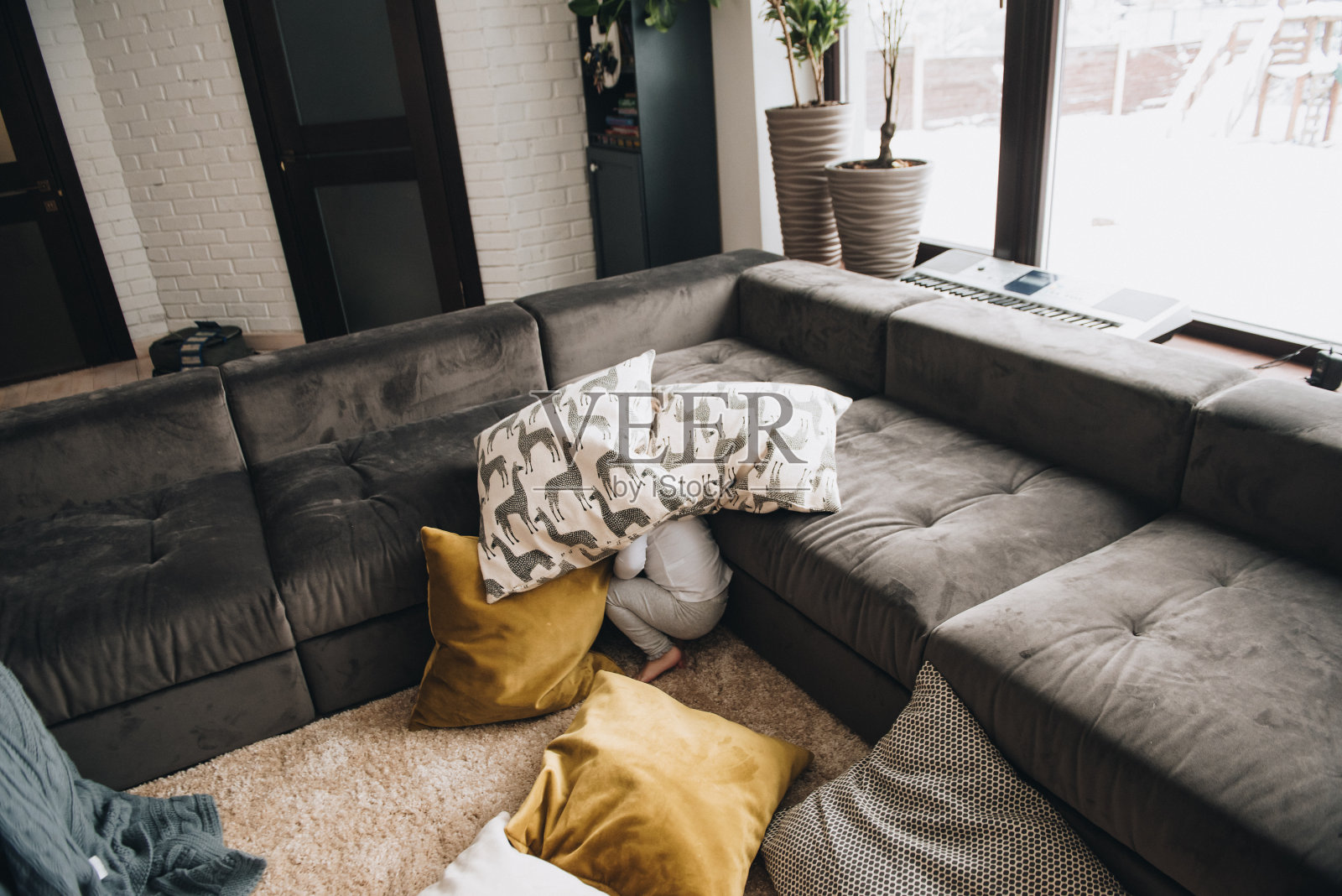 一家人住在大房子里。生活舒适。孩子在家里。那个女孩在地板上玩。躲躲猫。纺织。照片摄影图片