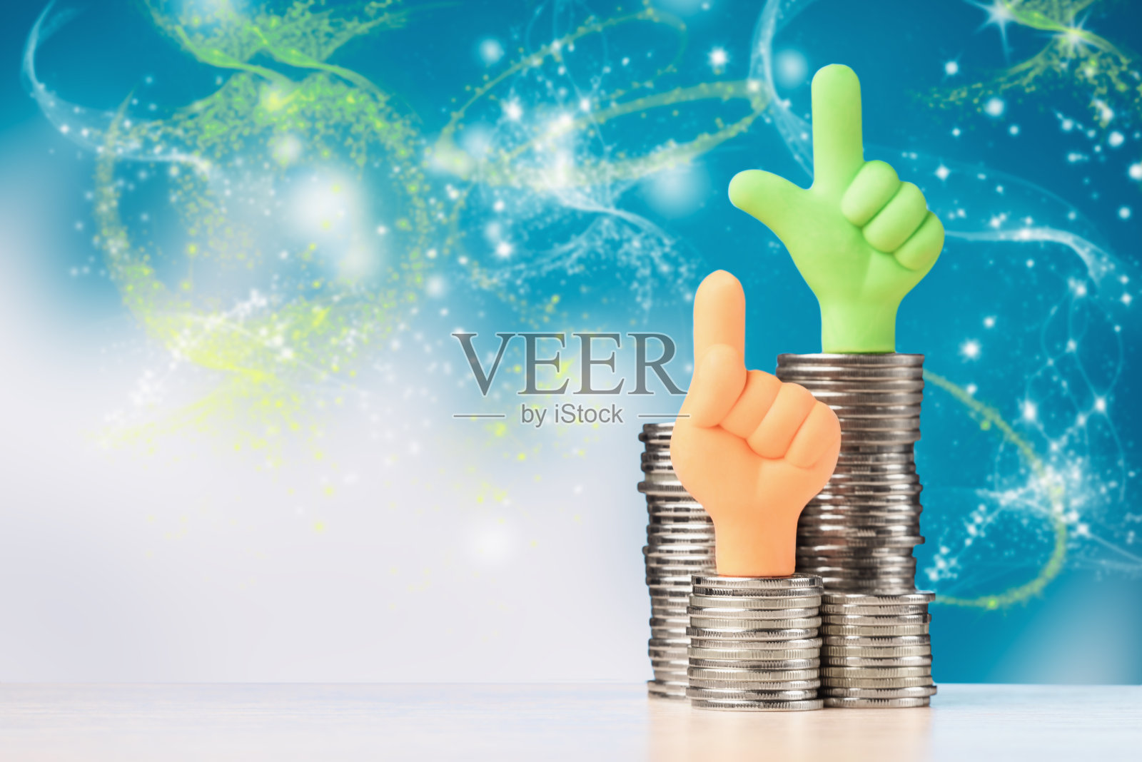 拇指朝上的手放在硬币堆上。投资增长的概念。照片摄影图片