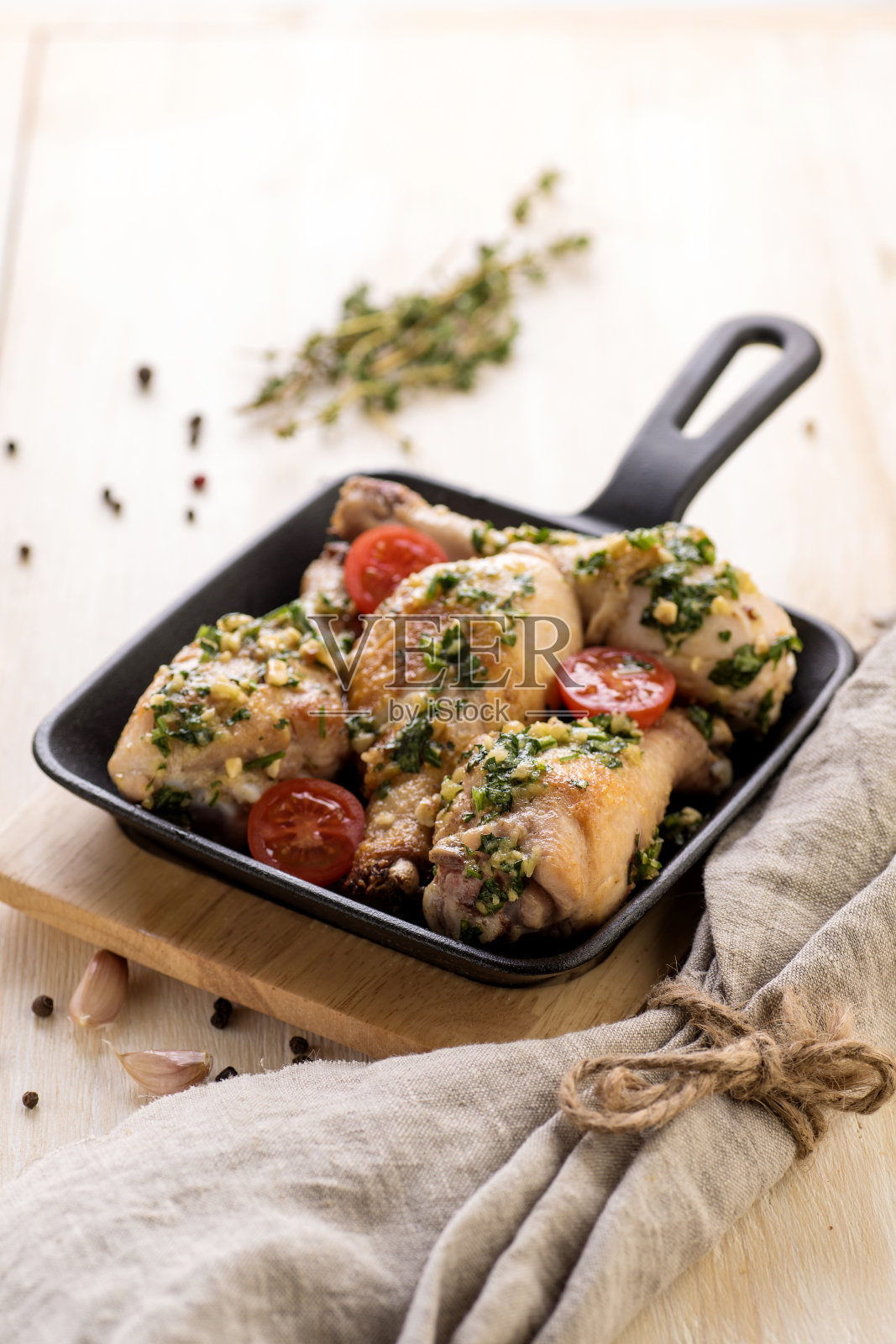 香蒜酱炸鸡配新鲜香草和樱桃番茄。照片摄影图片