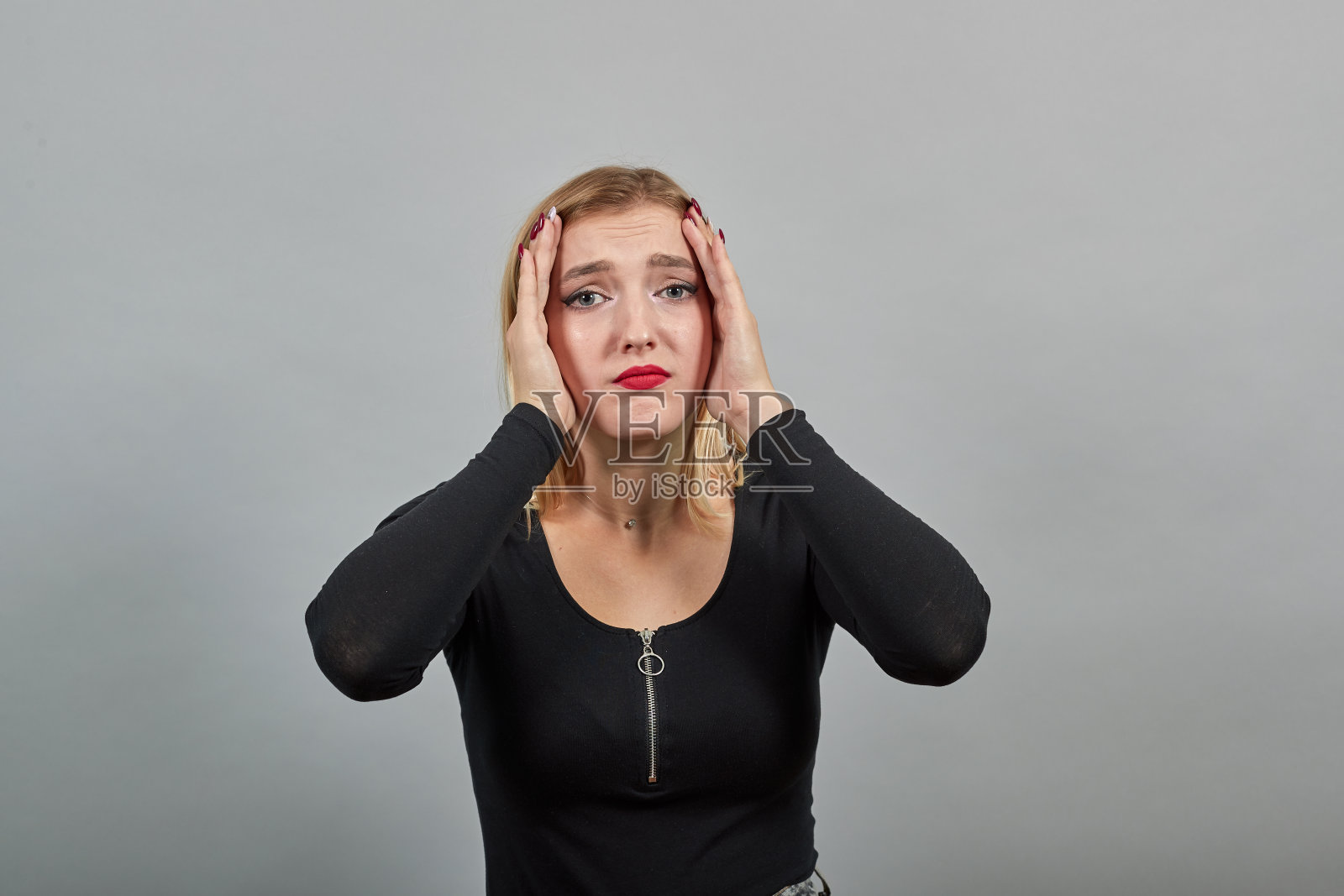 年轻的金发女孩在黑夹克发狂的女人抱着她的头在绝望照片摄影图片