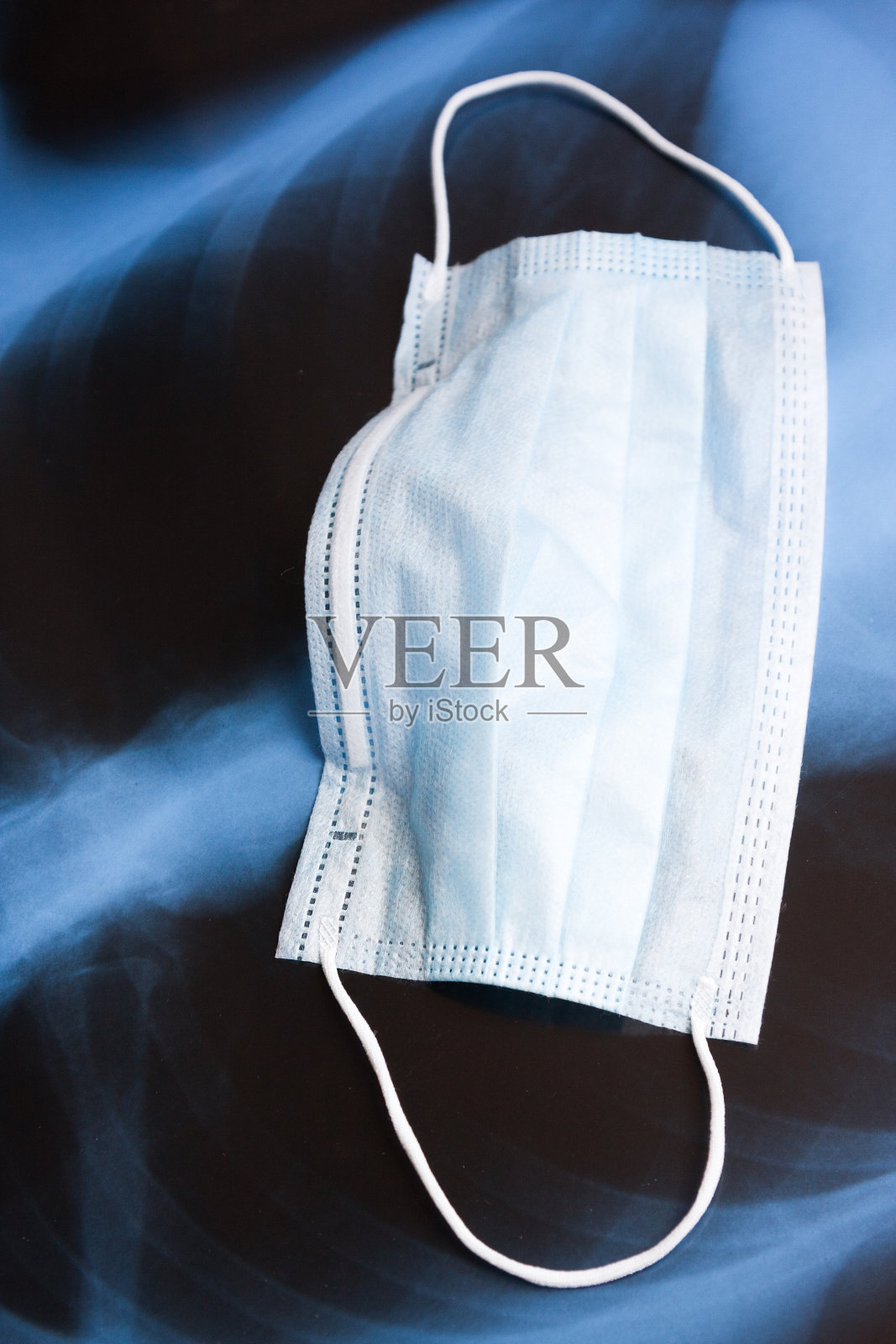 肺部x光片上的蓝色呼吸面罩，特写。冠状病毒- Covid-19疾病概念。照片摄影图片