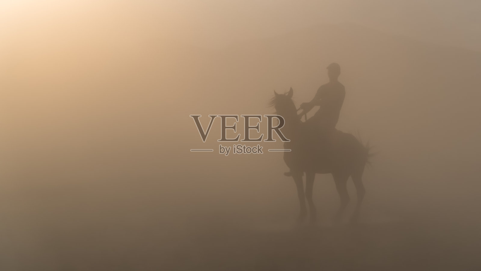 一名身份不明的男子在尘土和雾中骑马照片摄影图片