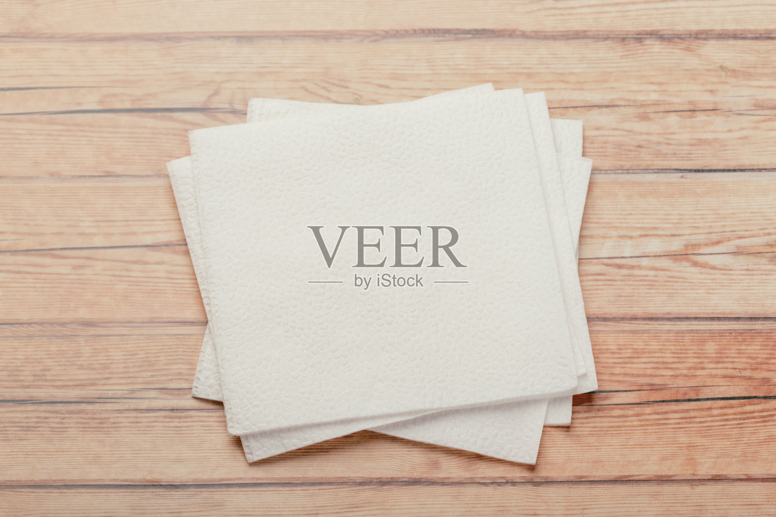 木桌背景上的餐巾或薄纸。照片摄影图片