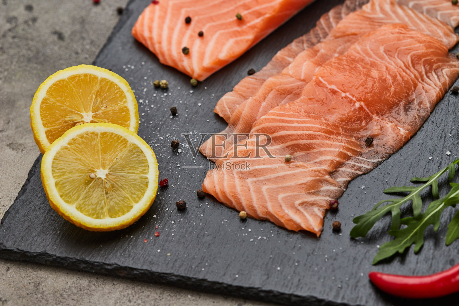 新鲜三文鱼片配芝麻菜，鳄梨和柠檬板。大西洋野生鱼照片摄影图片