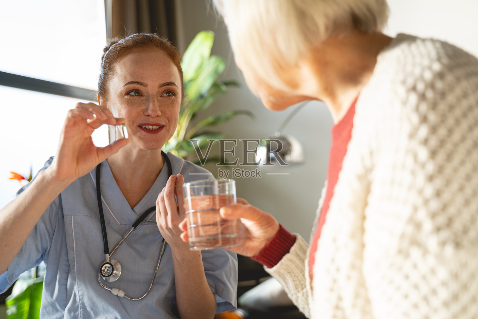 愉快的医务工作者正在咨询她成熟的病人照片摄影图片