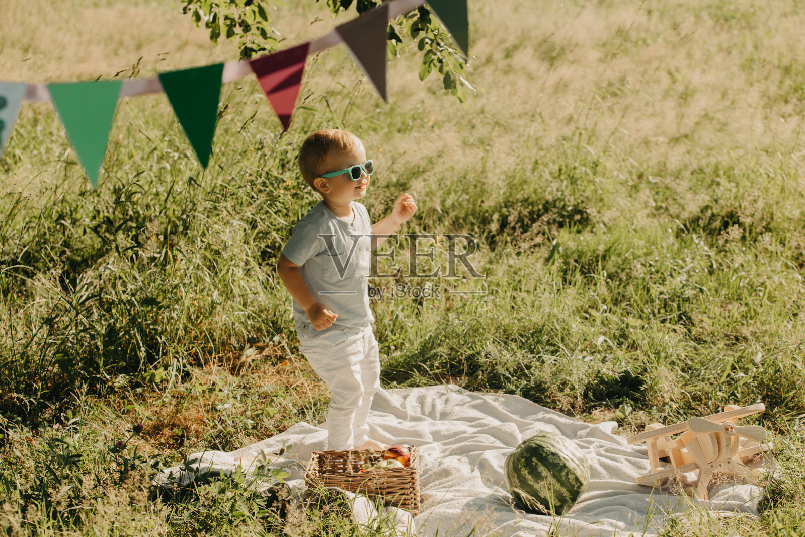在公园里戴着墨镜的可爱男孩。照片摄影图片