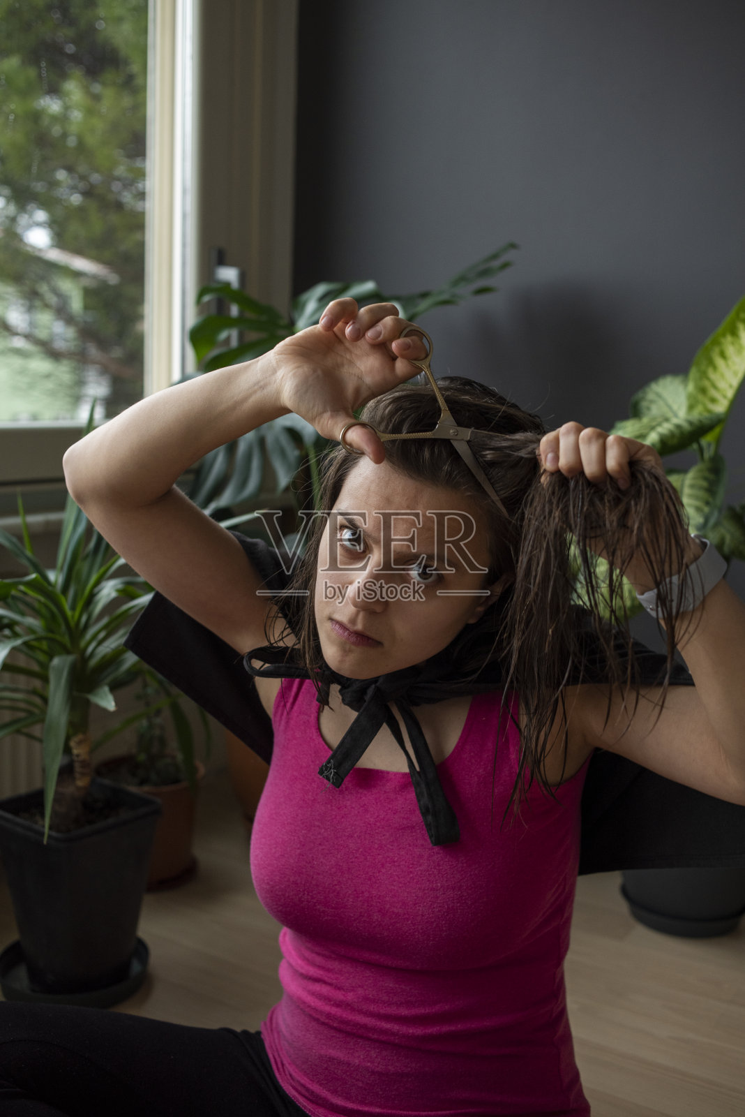 被隔离的女人自己剪头发照片摄影图片