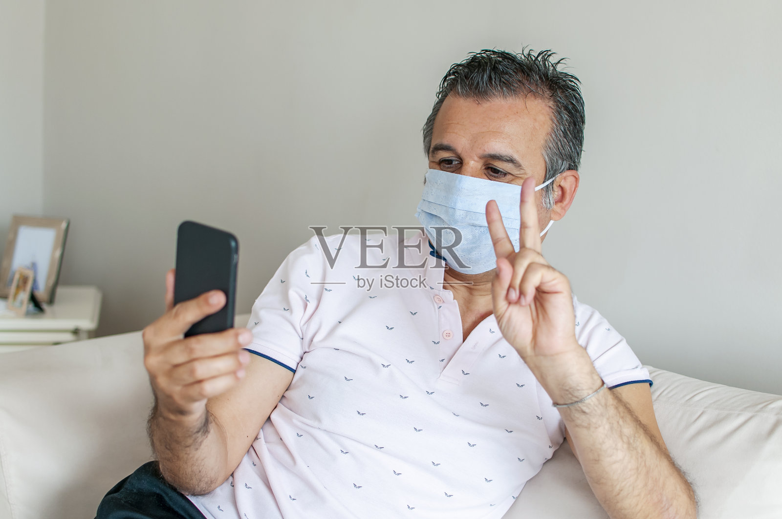 一个戴着防护面具的男人的肖像和手机照片摄影图片