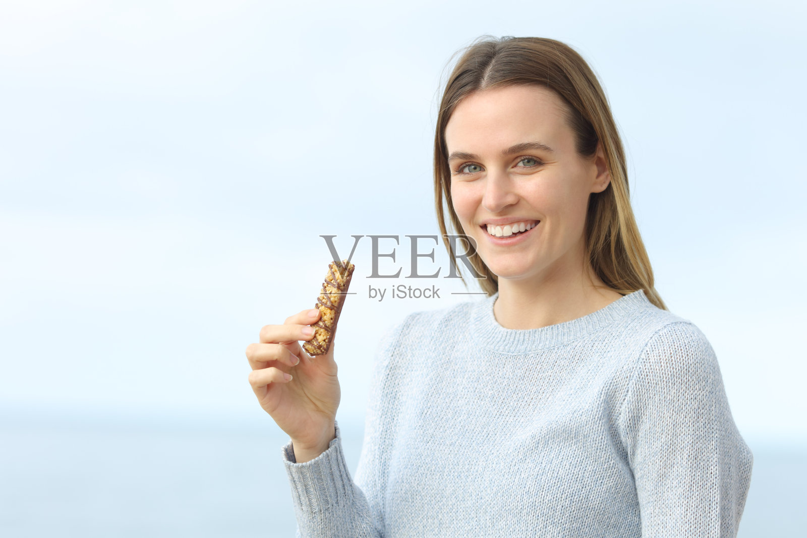 快乐的女孩在小吃店看着摄像机在海滩上照片摄影图片