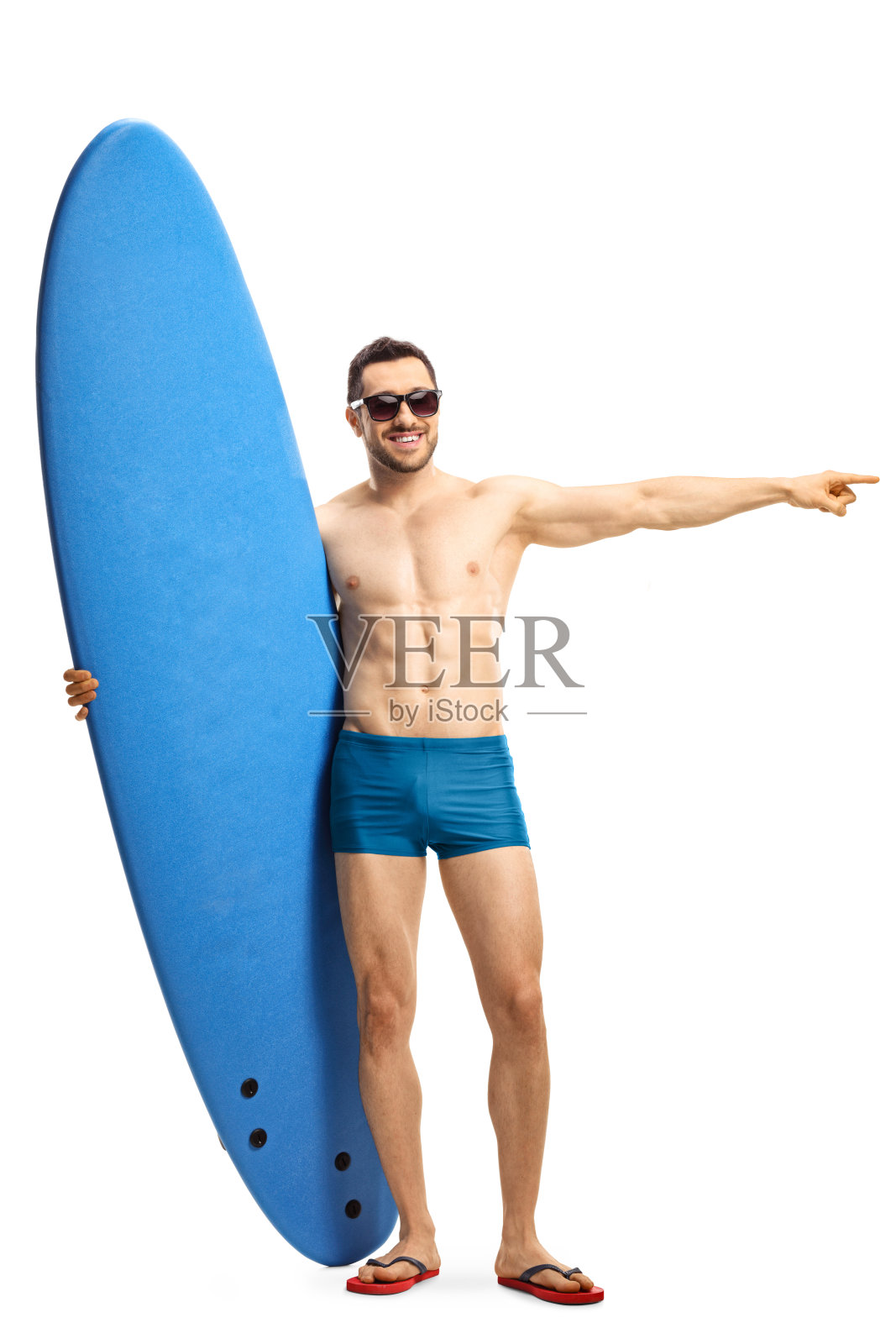 一个穿着泳衣戴着墨镜的男人拿着冲浪板指着一边照片摄影图片