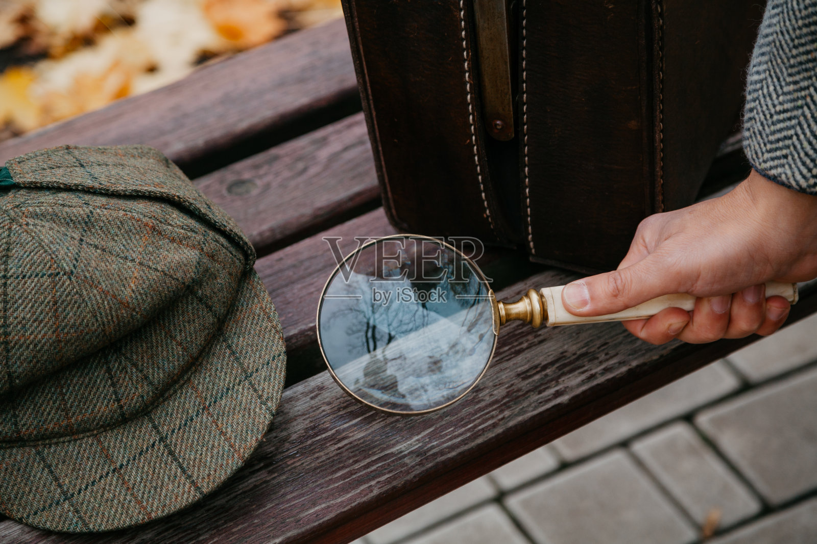 大的圆形放大镜，长柄在侦探手上照片摄影图片