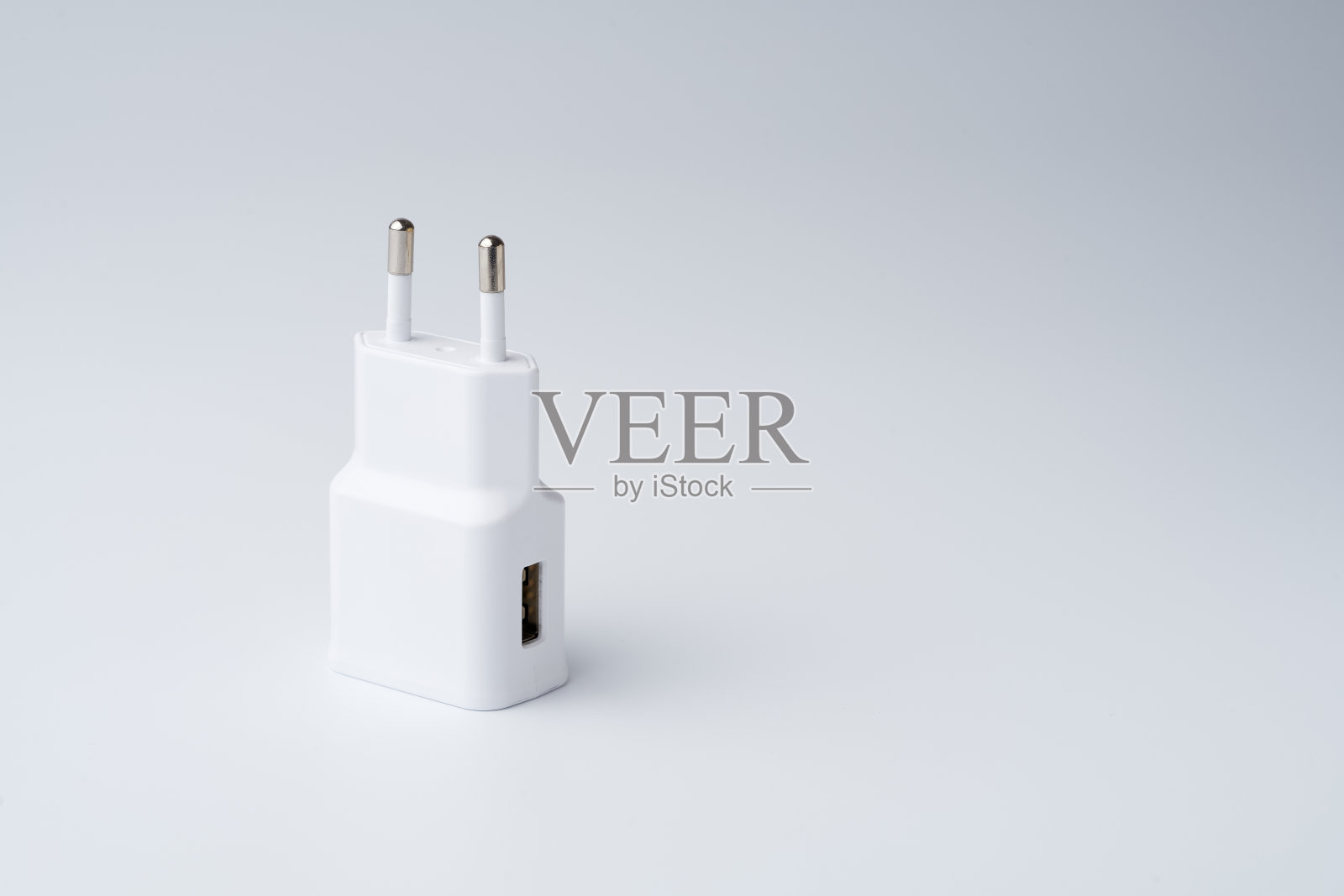 白色USB电源适配器的智能手机隔离在白色背景照片摄影图片