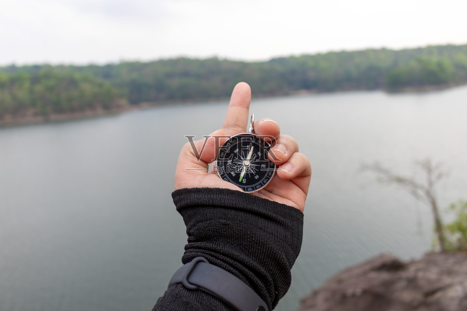 手拿指南针在山路上照片摄影图片