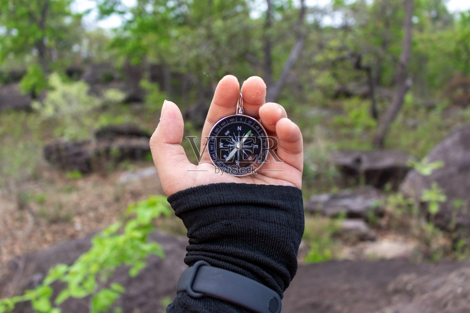 手拿指南针在山路上照片摄影图片