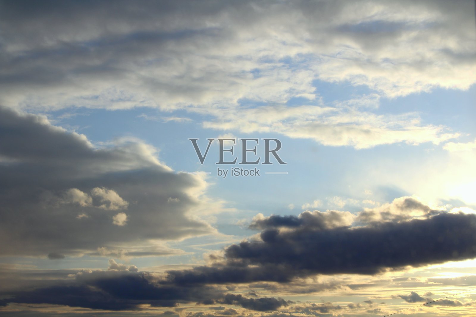 日落或黎明时蓝天上的云被太阳背光照亮。放置文本和设计照片摄影图片