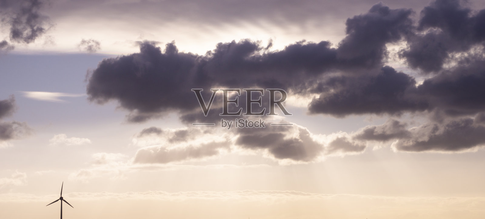 风力涡轮机发电机与戏剧性的云背景照片摄影图片