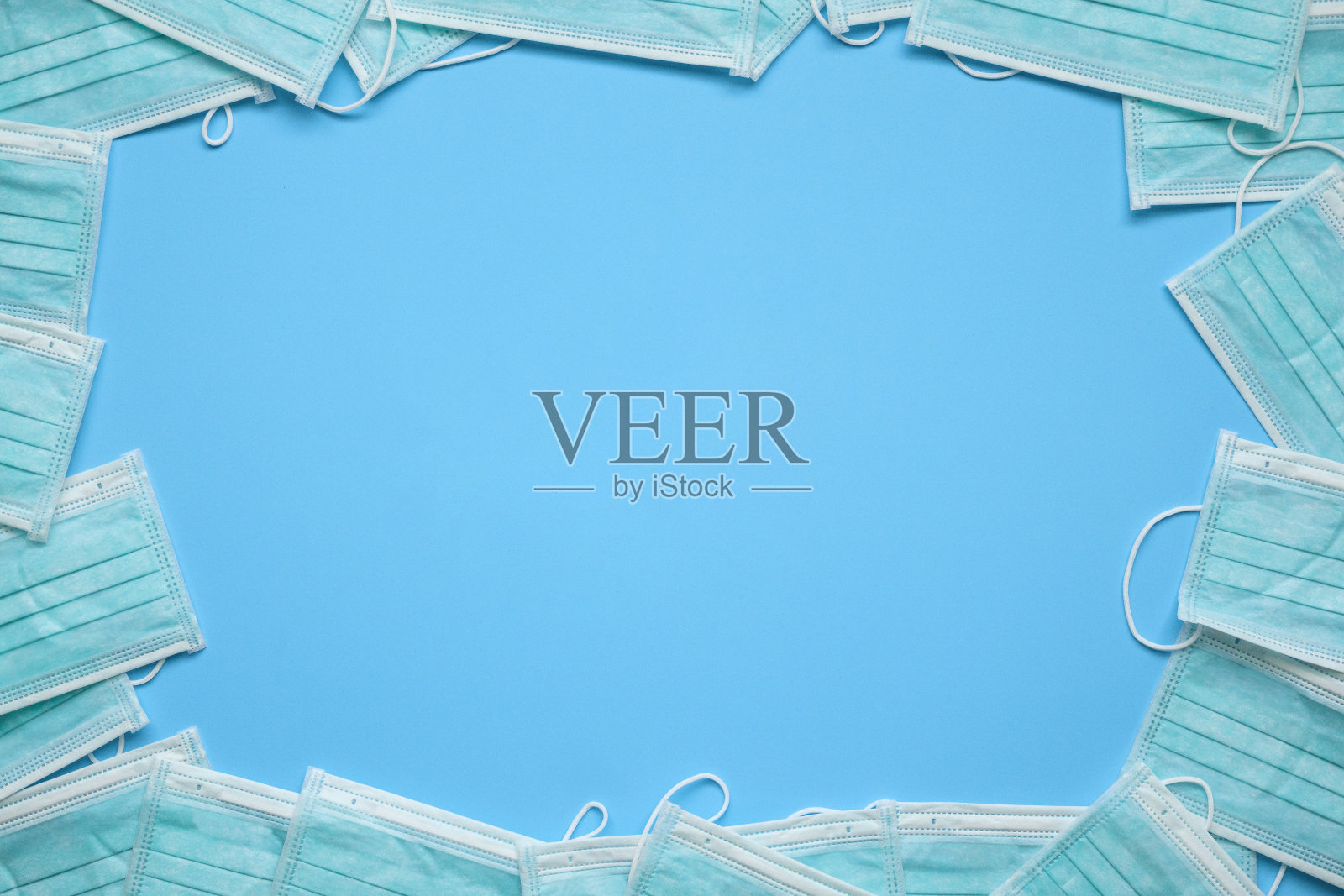 蓝色背景的外科口罩，可预防COVID-19冠状病毒。医疗保健和医疗概念与复制空间照片摄影图片