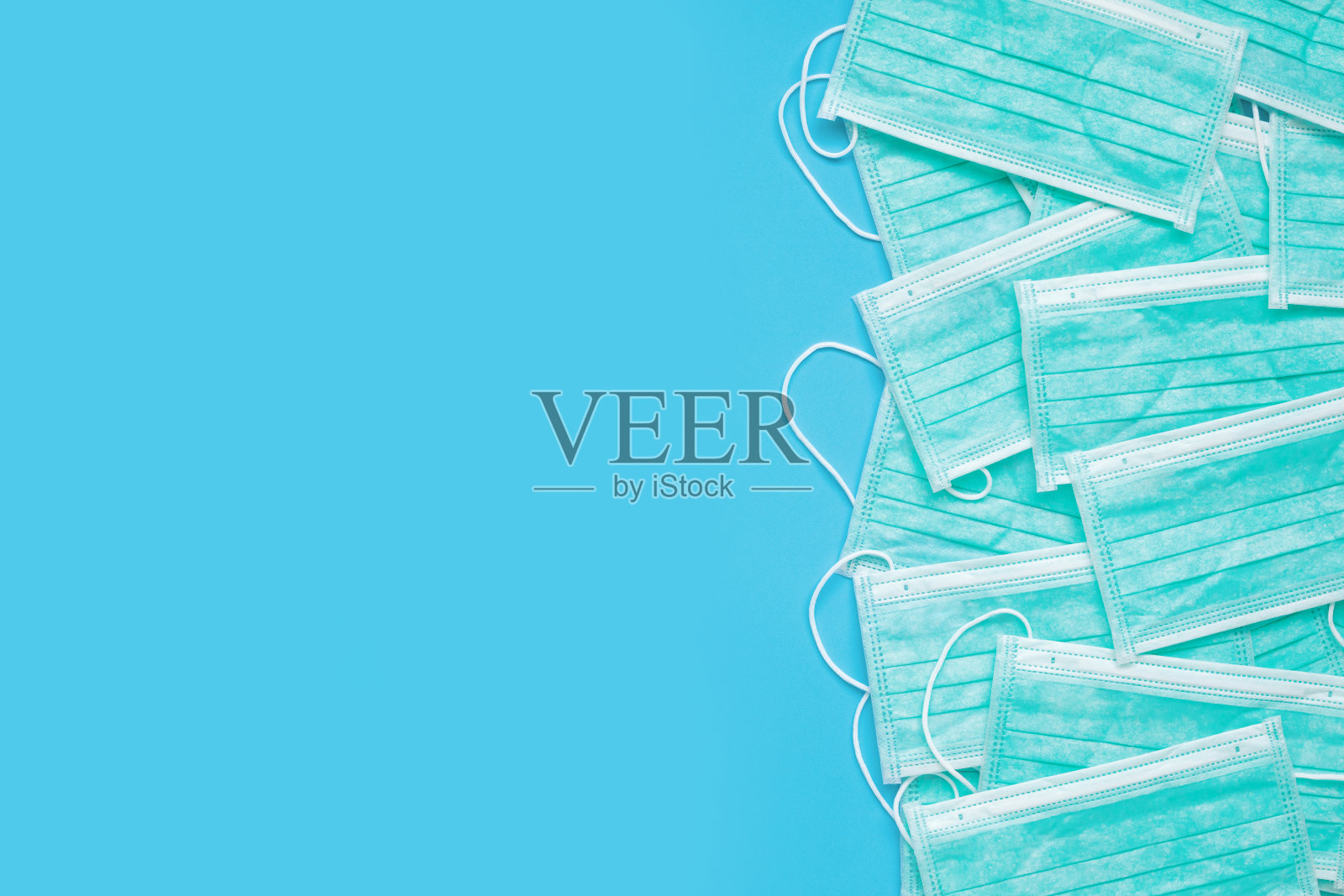 蓝色背景的外科口罩，可预防COVID-19冠状病毒。医疗保健理念照片摄影图片