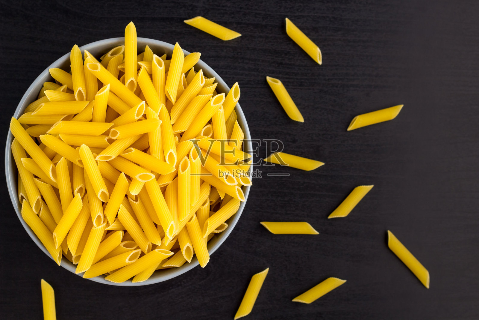俯视图黑色背景与意大利生通心粉或意大利面碗复制空间照片摄影图片