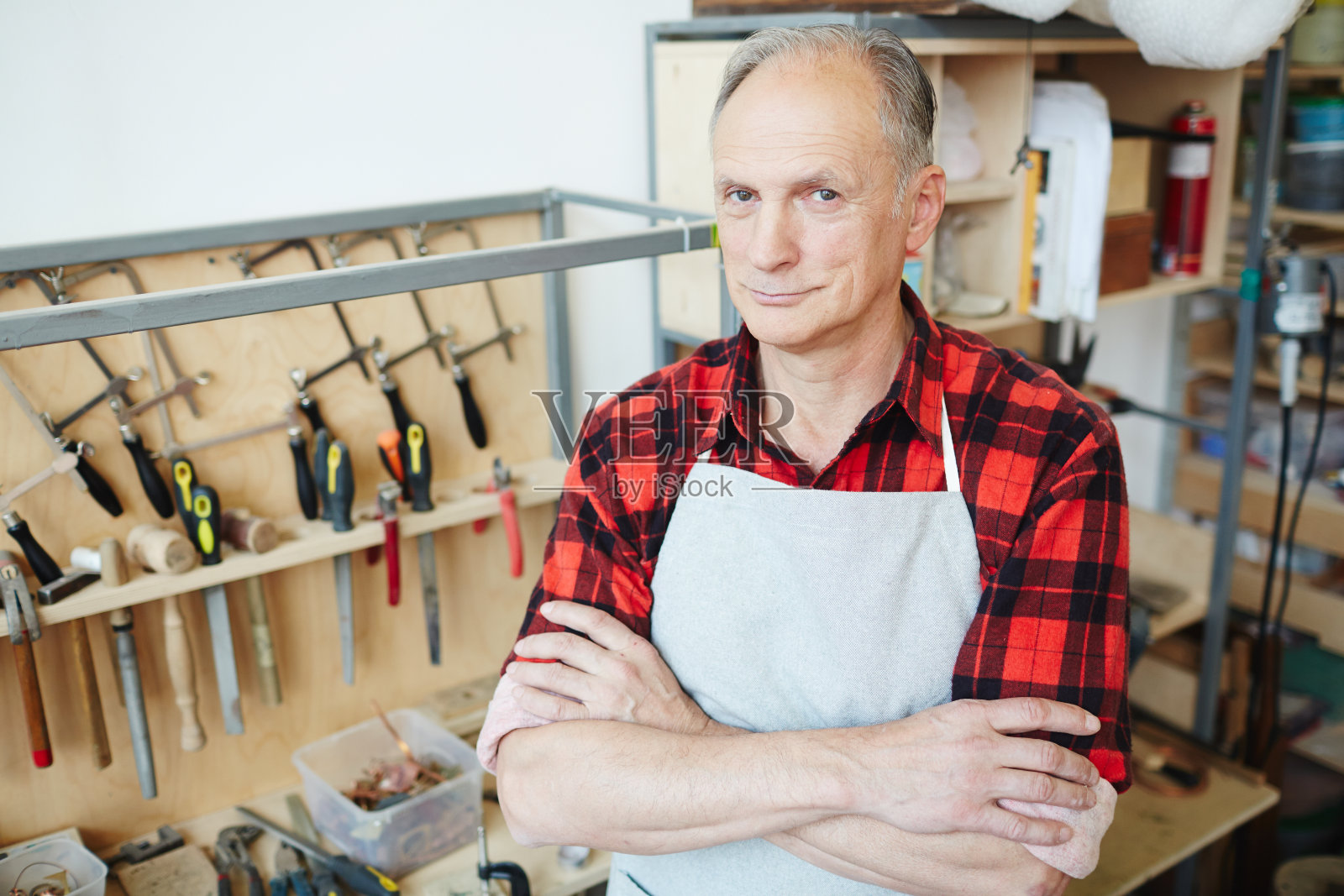 内容自信的工匠站在工作台照片摄影图片