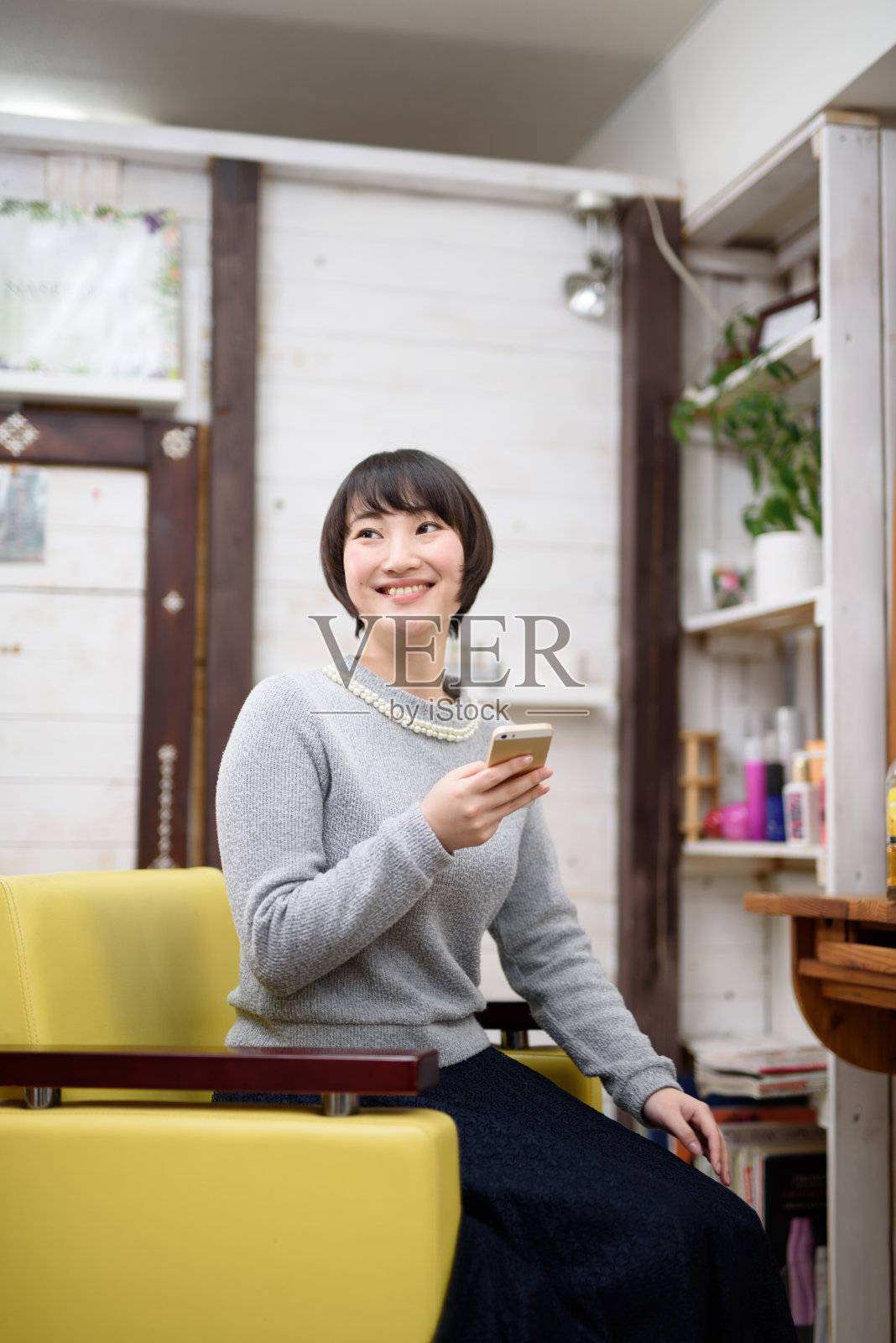 年轻女子在发廊用智能手机照片摄影图片