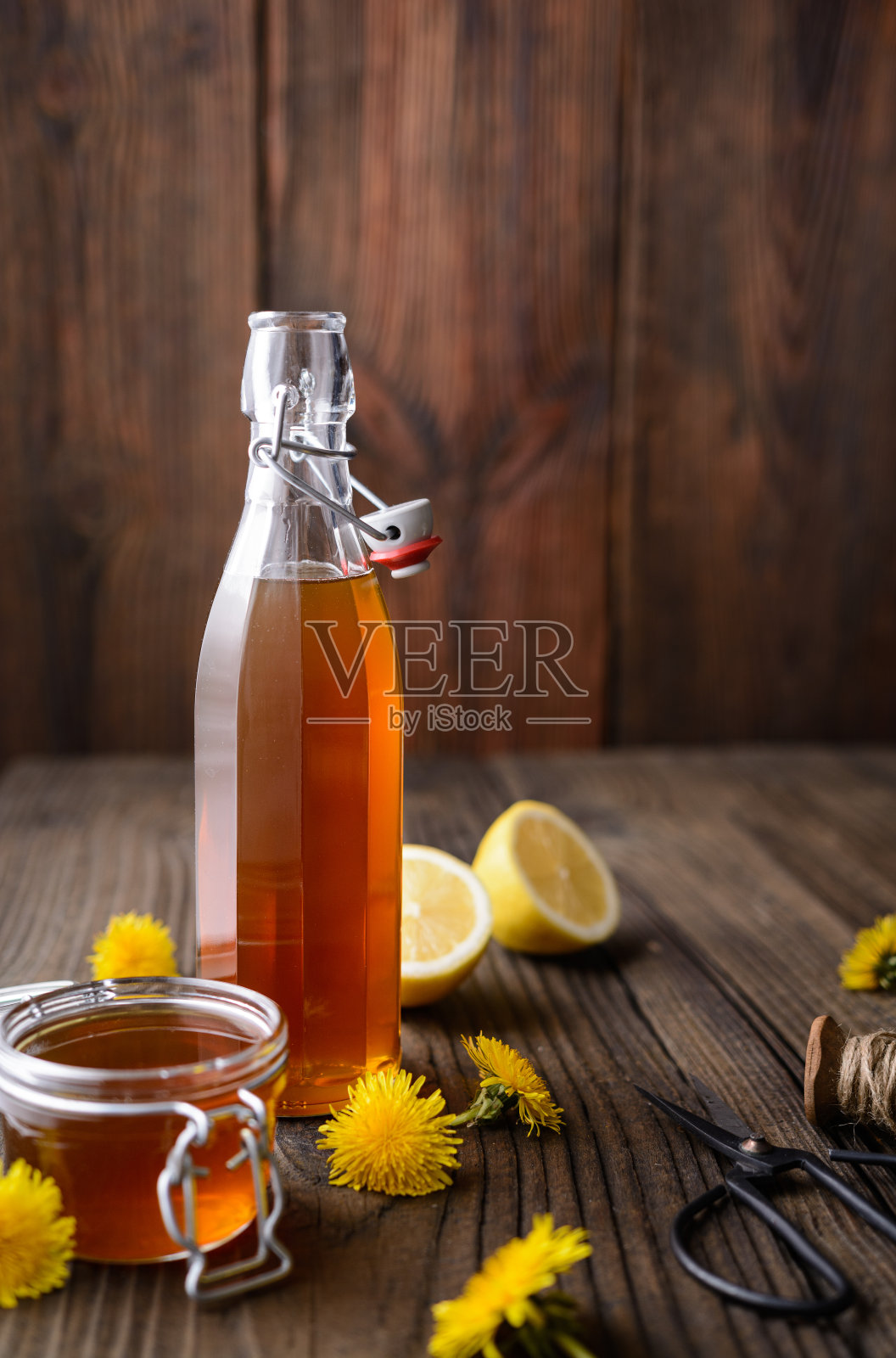 自制健康的蒲公英糖浆装在玻璃瓶里，用鲜花装饰有拷贝空间照片摄影图片