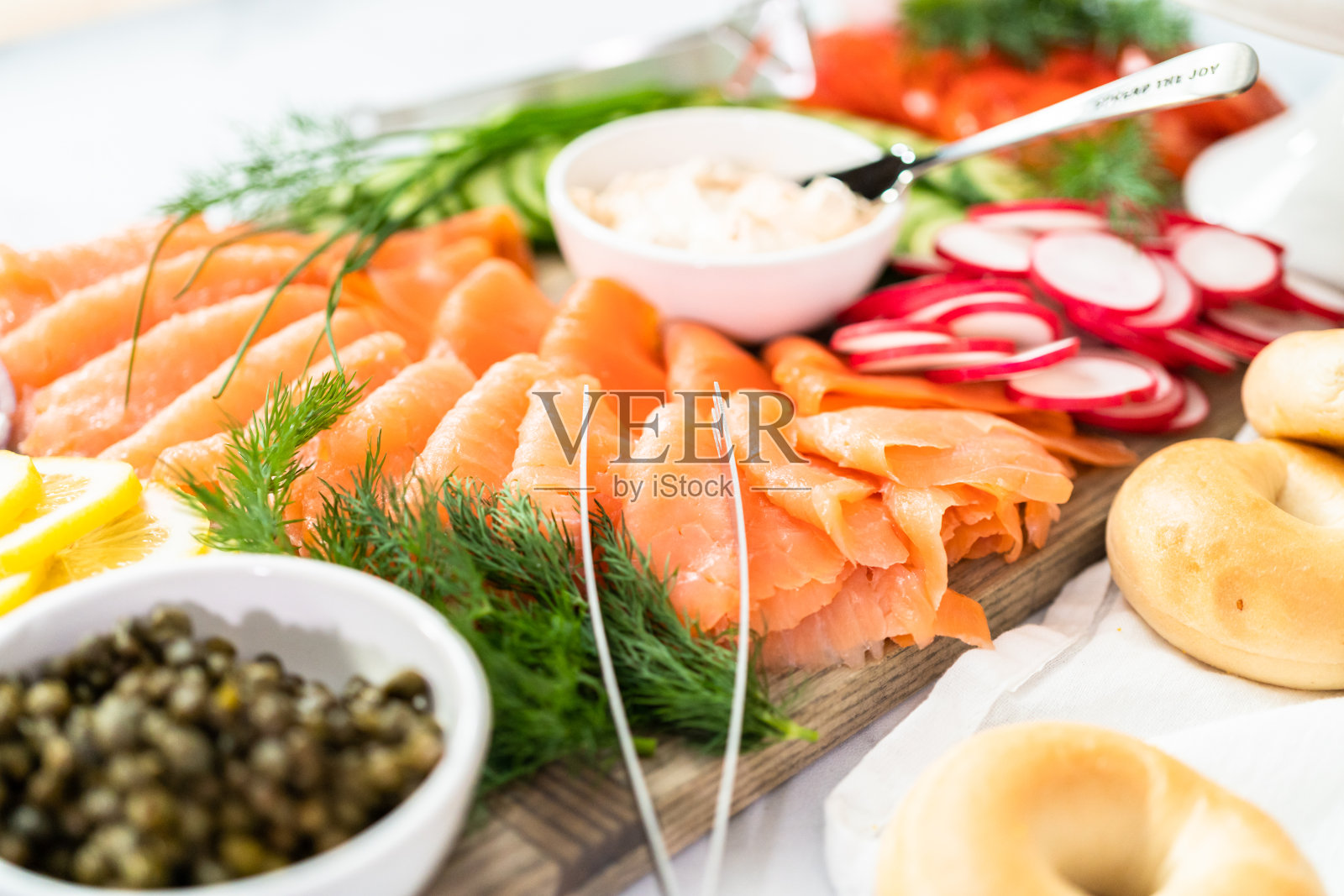 熏鲑鱼和新鲜蔬菜的百吉饼早午餐。照片摄影图片