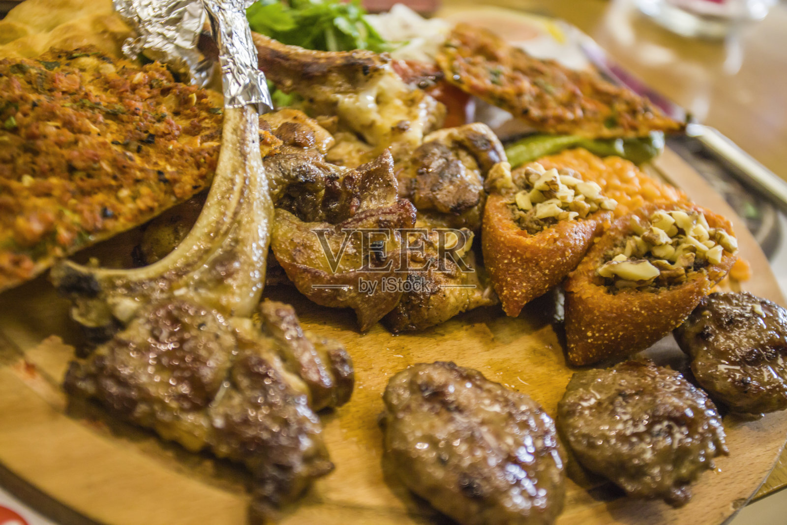 放在木盘上;菜肴有肉，肉丸，西红柿和绿色蔬菜- icli kofte - kofte - lahmacun照片摄影图片