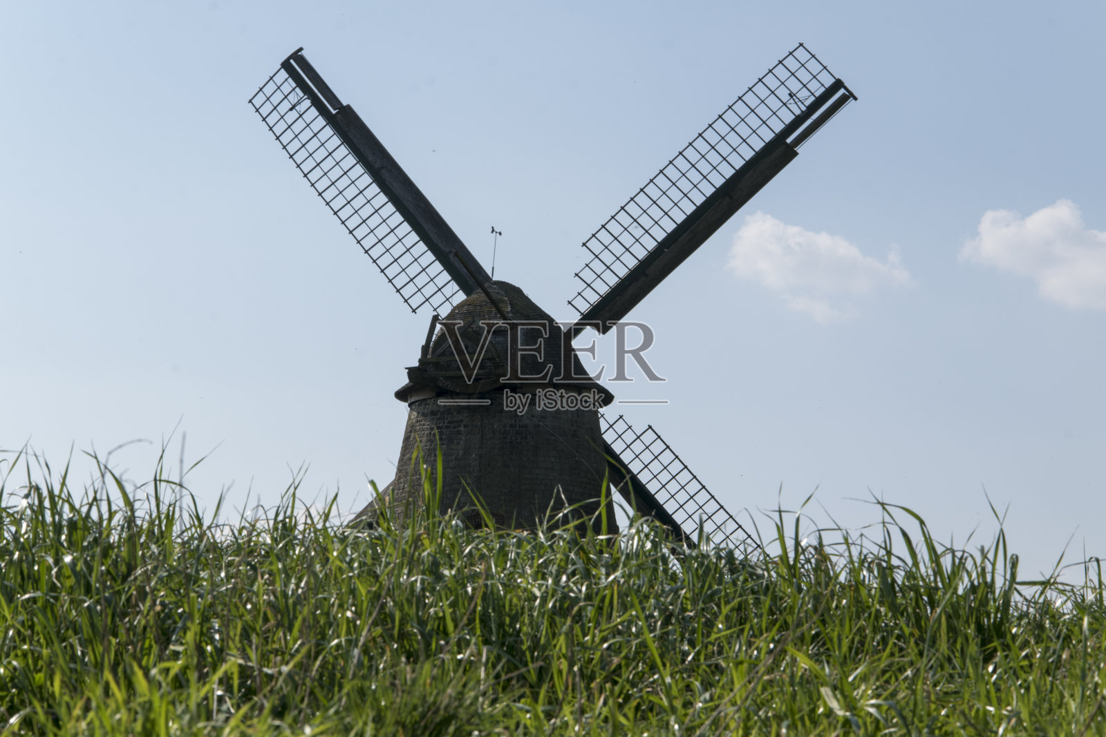 下萨克森州霍耶尔梅尔地区草地和田野之间的风车。一张背光的照片。照片摄影图片