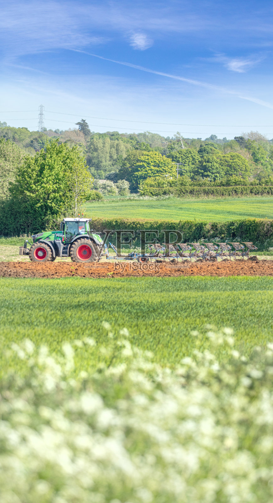 在科茨沃尔德地区，拖拉机正在犁地，为播种夏季小麦准备土壤。照片摄影图片