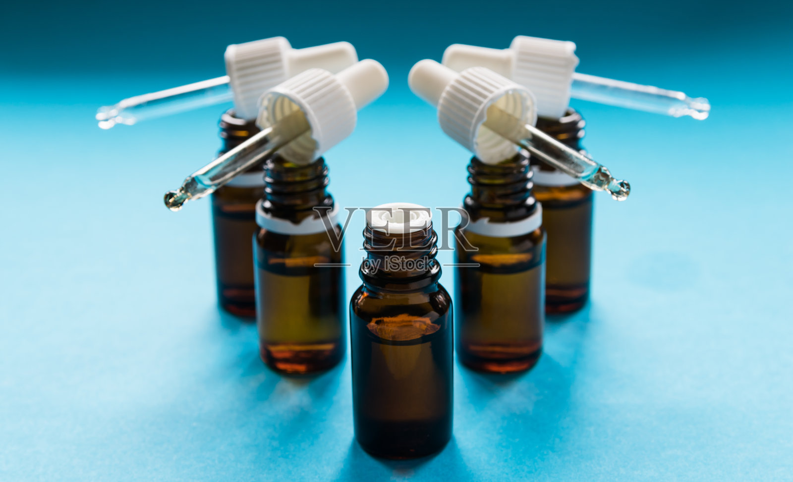 美容，带吸管的玻璃瓶和化妆品在蓝色的背景照片摄影图片