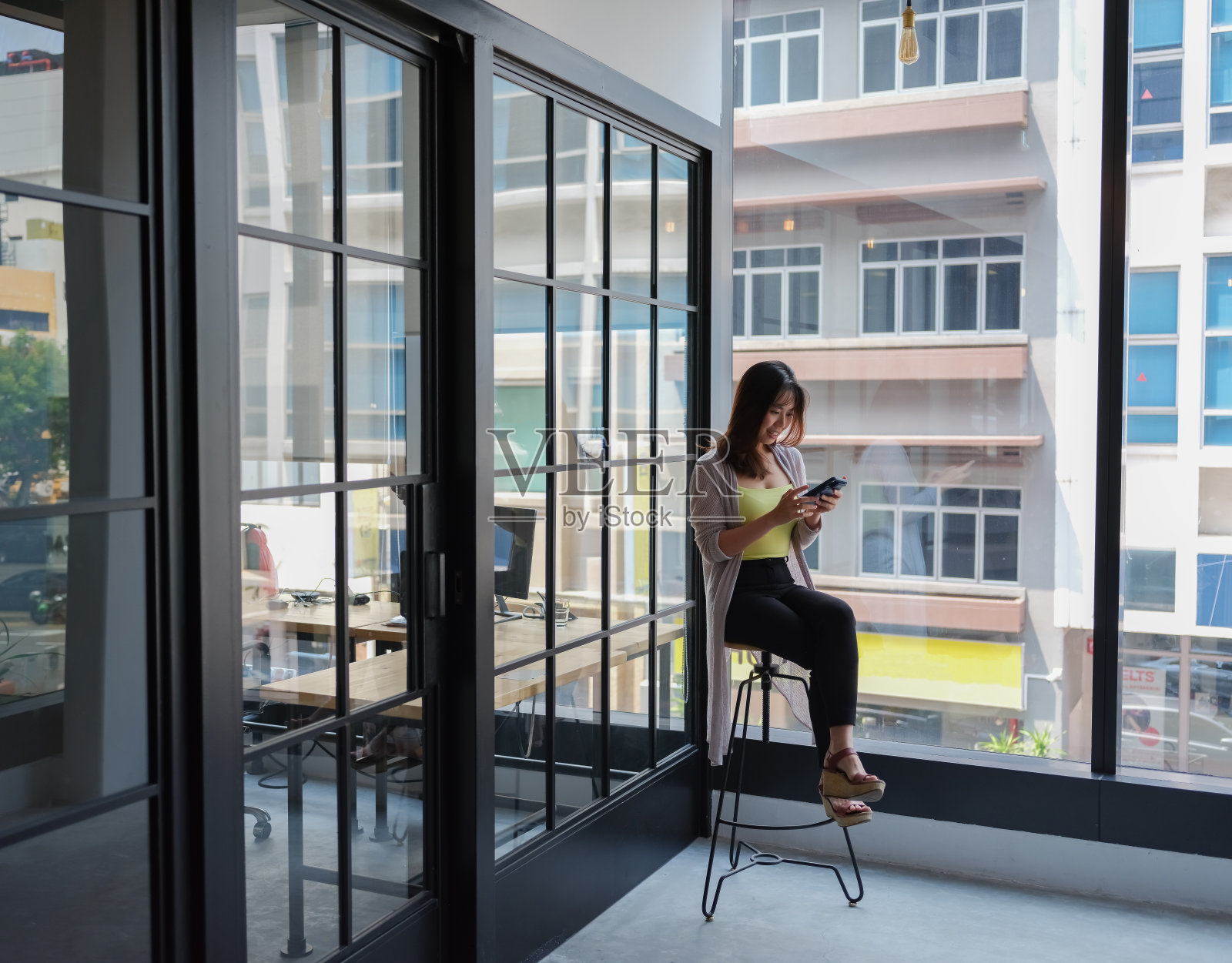 年轻的亚洲女孩在办公室使用手机照片摄影图片