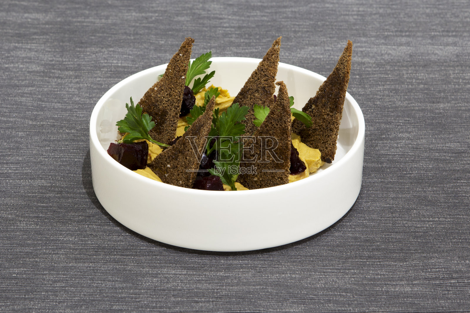 土耳其脑袋。火鸡鸡胸肉配洋葱，胡萝卜，大蒜，酱油，奶油和百里香。配上香油烤甜菜、黑麦面包丁和新鲜欧芹叶照片摄影图片