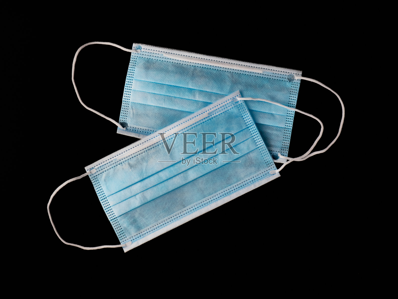 黑色背景上的两个医用口罩。预防Covid-19病毒或冠状病毒的口罩。照片摄影图片