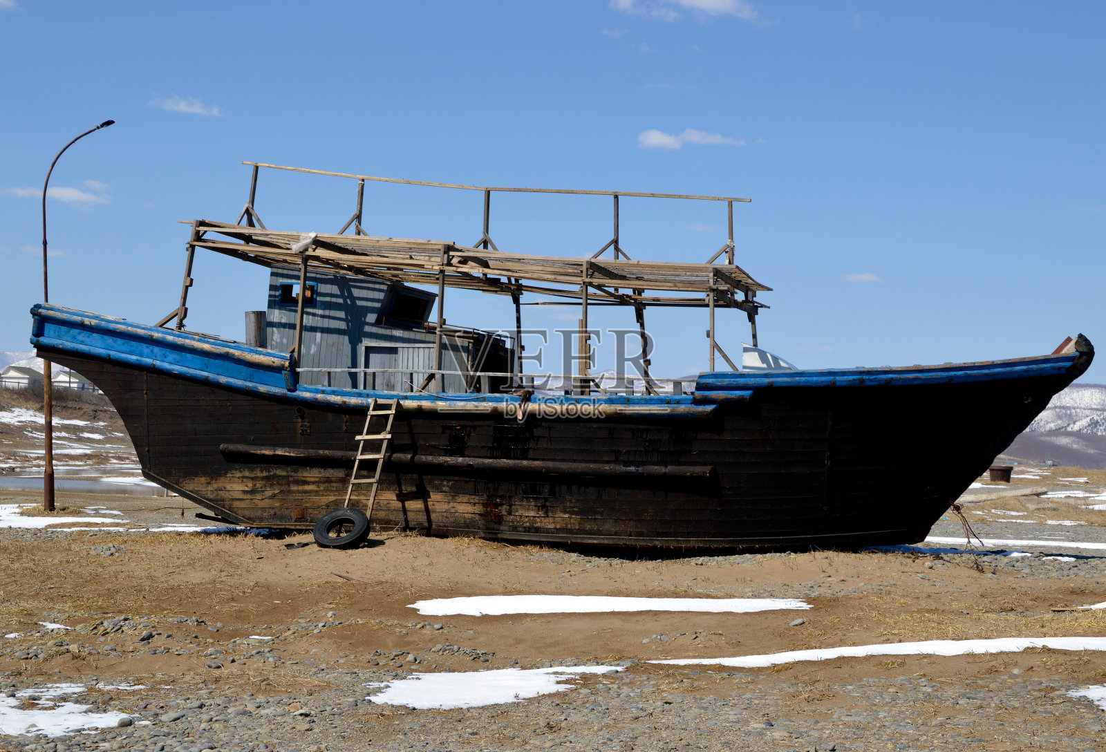 在俄罗斯滨海的日本海岸边，一艘被遗弃的朝鲜渔船。照片摄影图片